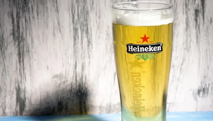 Copo com cerveja Heineken